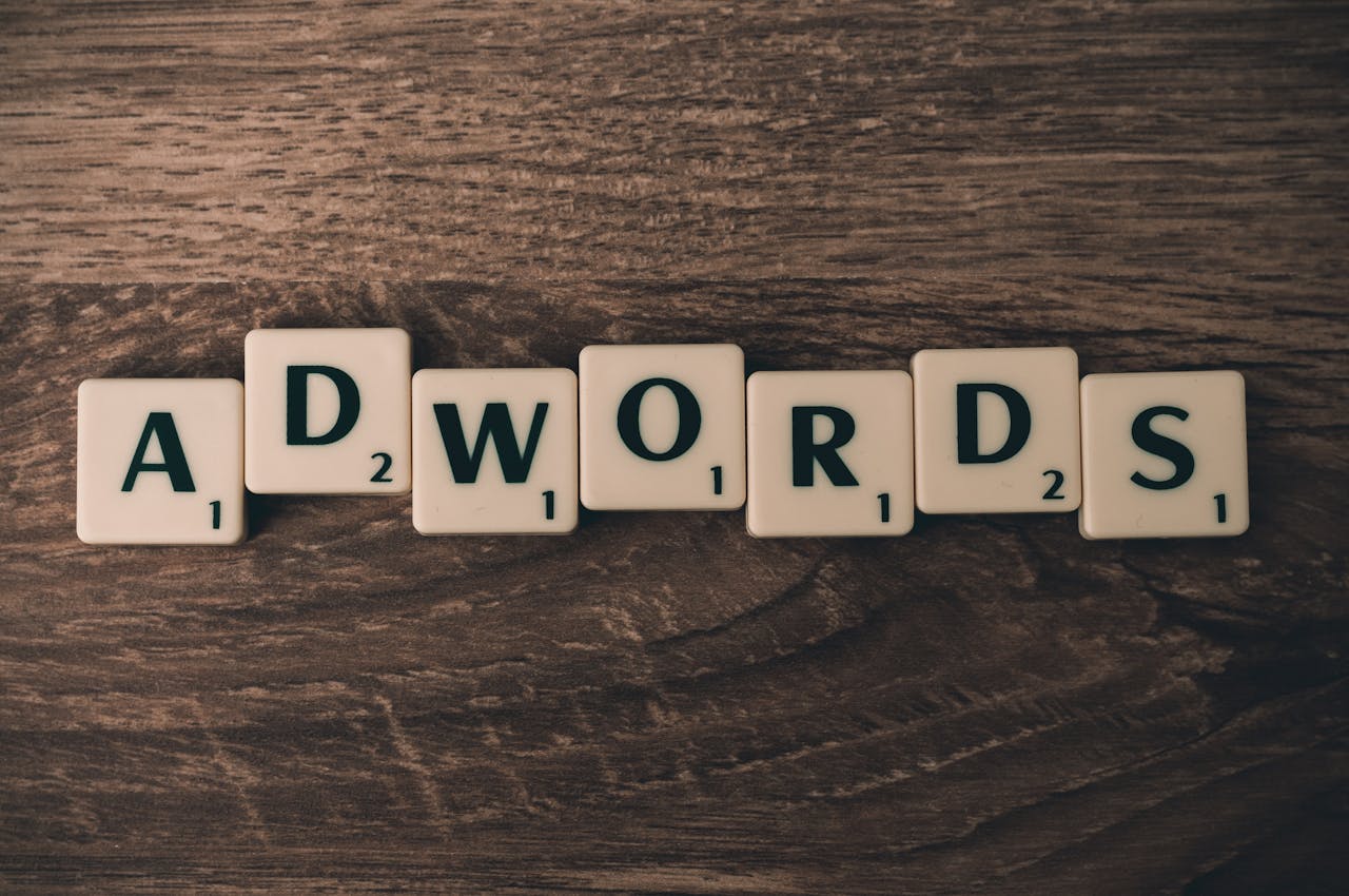 cta-bg Scrabble tiles spelling AdWords on a wooden surface, symbolizing digital marketing concepts.